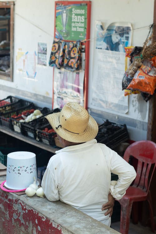 Man-in-Hat-Selling-on-Outdoor-Market