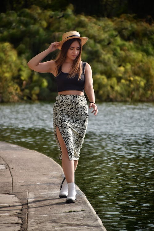 Woman-in-Hat-Walking-near-Lake