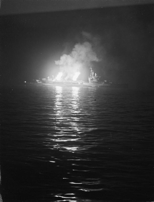 HMS Belfast's 4-inch guns bombarding German positions in Normandy at night