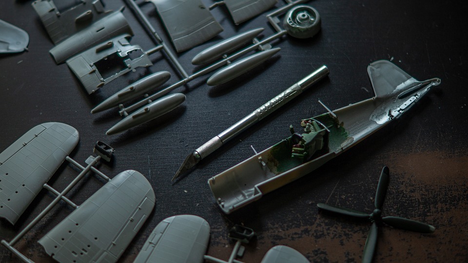 a skill level 5 model kit of a plane on the table with parts and a sharp tool