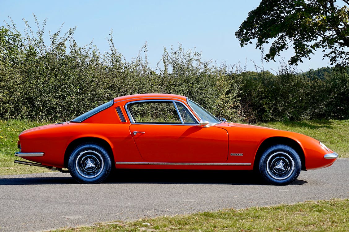 a red Lotus Elan parked on the sidewalk