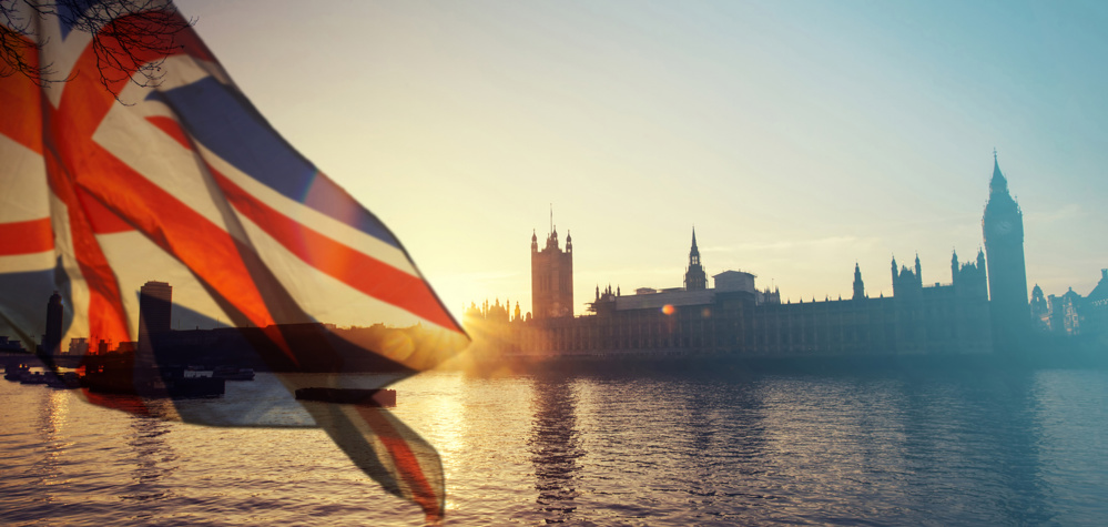 British union jack flag and Big Ben Clock Tower and Parliament house at city of Westminster in the background - UK votes to leave the EU, Brexit concept