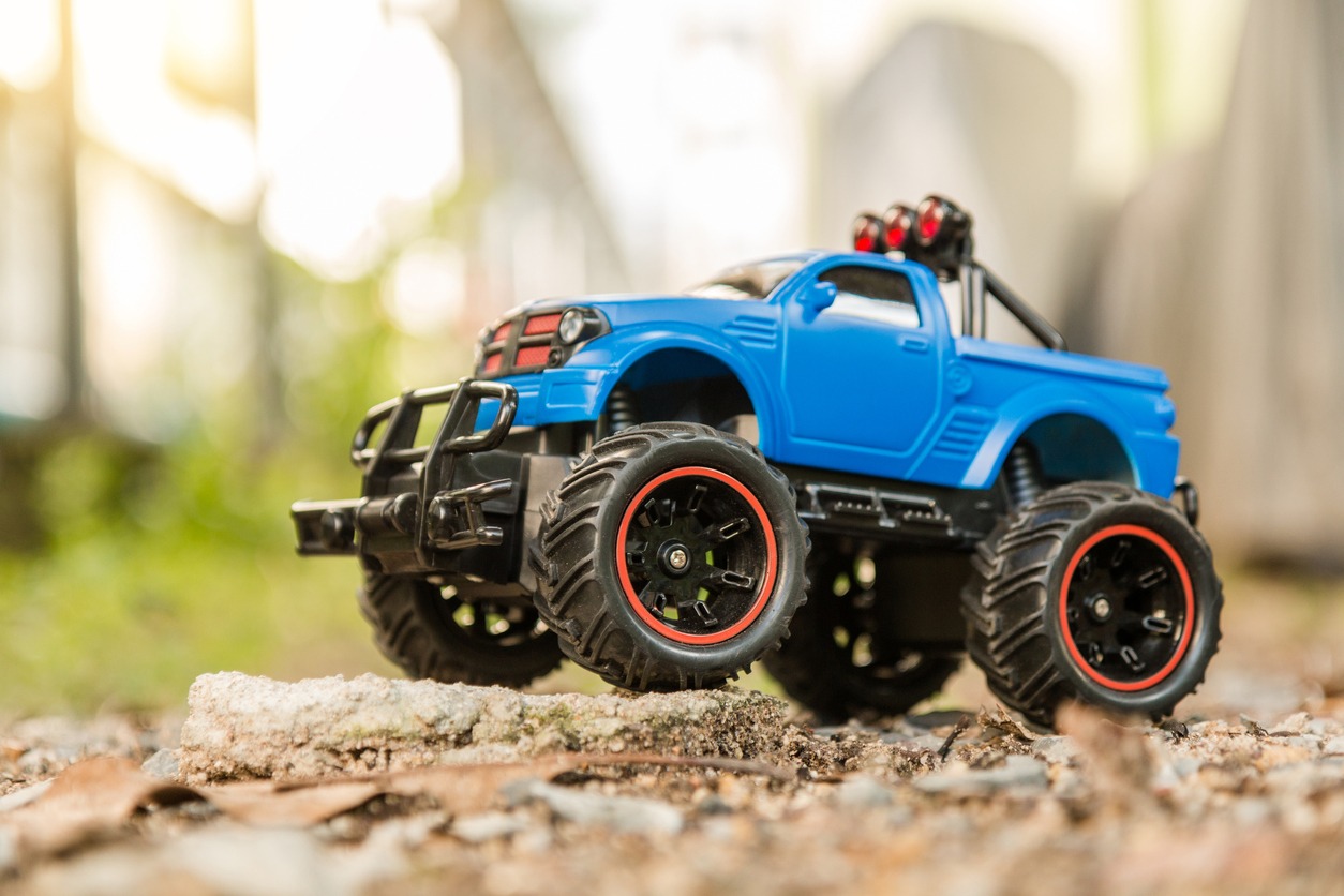Blue RC Off-road truck car (Radio-controlled) standing on the rock and terrain sand dune